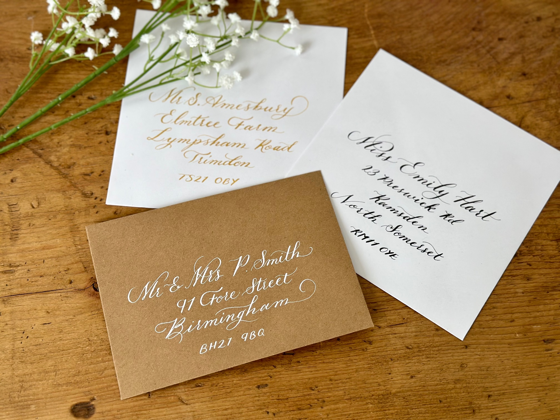 Hand-addressed envelopes in black, gold and white calligraphy